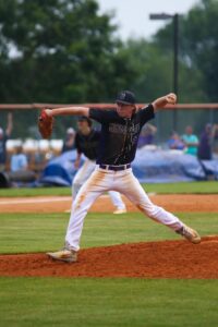 A baseball pitcher in a determined pose during a game outdoors.